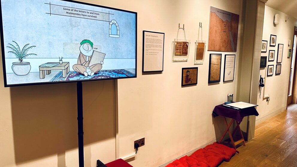 View of the Maimonides exhibition at the Manchester Jewish Museum with a creen on the wall and a number of exhibits